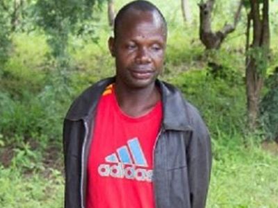 Adam Mwale is wearing a black jacket and a red adidas shirt.